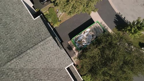 Aerial Footage of Dumpster Full of Garbage From an Home