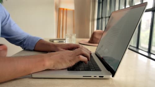 Hands of Man Typing on Keyboard of Laptop Computer and Working in Home Office