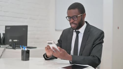 Man in Suit Celebrates Success With Smartphone