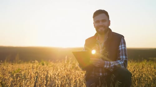 Farmer Inspecting Crops in Field at Sunrise