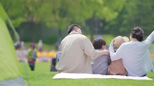 Happy family in the outdoor outing having a picnic in the park