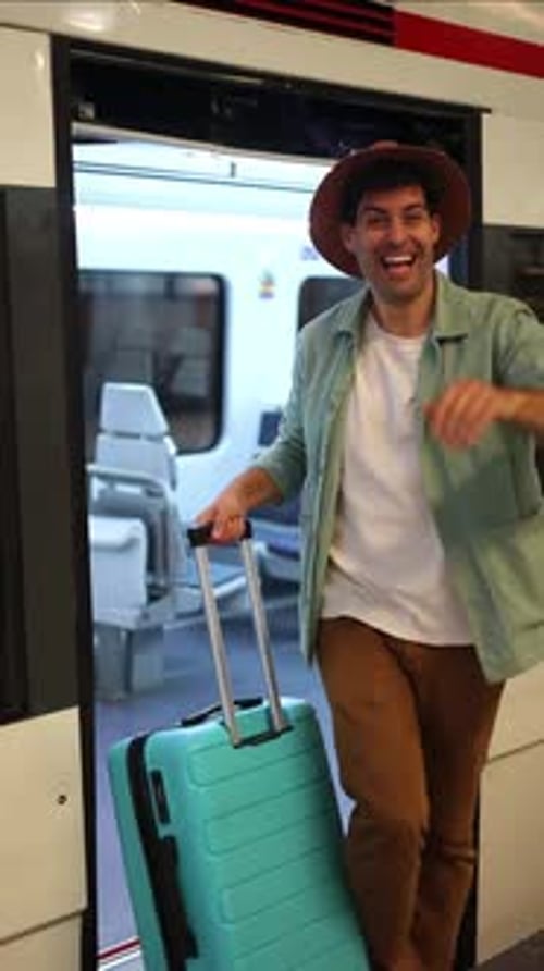 viajante vertical acenando para a câmera ao descer do trem, feliz por se reunir após uma longa viagem