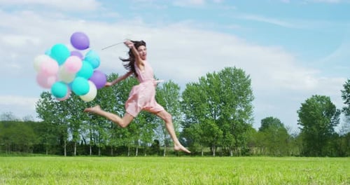 Young Woman Runs with Balloons in Grassy Field