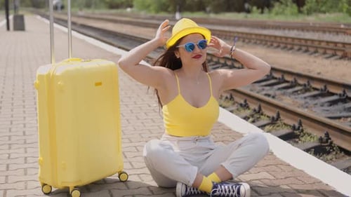 Young Woman with Suitcase Waiting for Train