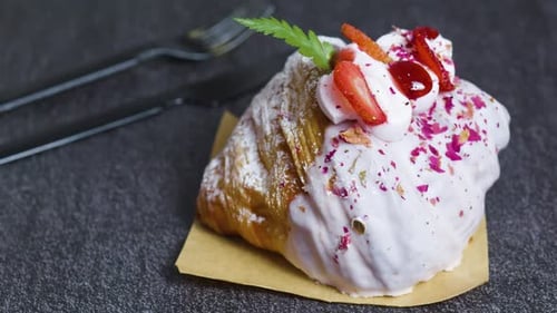 Delicious Croissant Topped with Icing and Strawberries