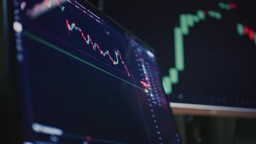 Trader Home Office Monitor and Laptop are on the Table Trading Program or an Exchange Charts and