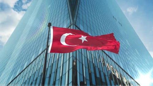 Waving Flag of Turkey Against Modern Skyscraper Backdrop