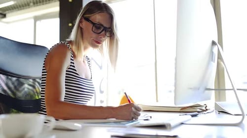 Confident young businesswoman works at her computer in a modern office