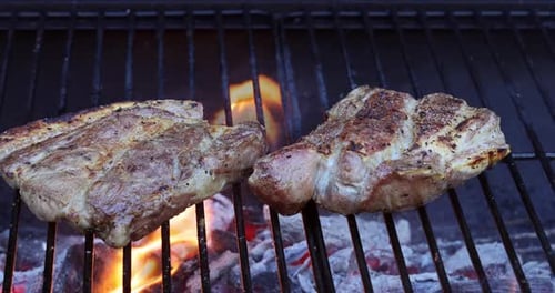 On the Flame of Smoke I Am Grilling Delicious and Juicy Meat Pork Steaks in the Style of Barbecue
