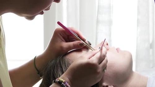 Eyelash Extensions Applied to Woman by Aesthetician