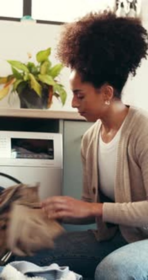 Young Woman Doing Laundry at Home in Apartment