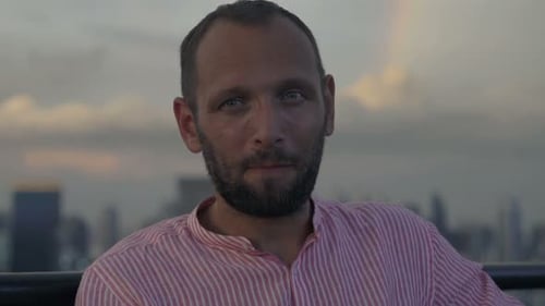 Portrait of Happy Man Talking and Raising Toast with Drink in Skybar Alcohol
