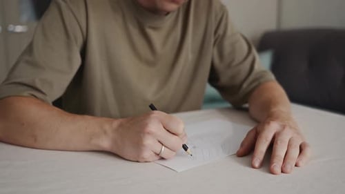 Man Drawing on Paper at Home Indoors