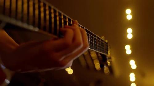 Hands Playing Guitar in Intimate Lighting