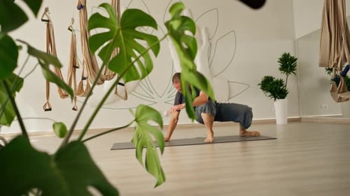 Man Practices Yoga in Bright Studio