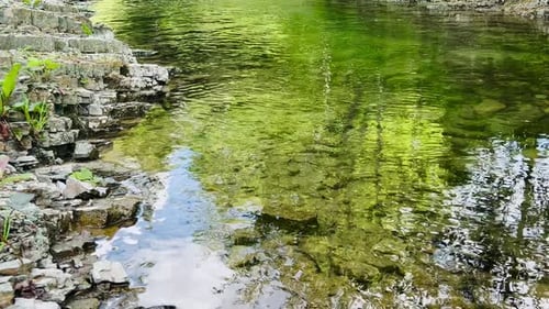 A transparent mountain river flows among the stones.