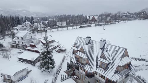 Drohnen-Luftaufnahmen des kleinen Bergdorfs bei verschneitem Wetter