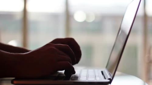 Homem digitando em um laptop no negócio doméstico