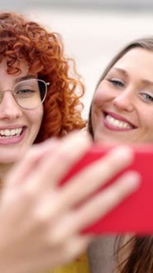 Smiling Women Taking Selfie with Phone in City