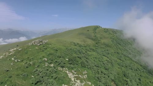 Aereal drone shot location mountain, sunny weather and movement from bottom to top. Clouds and clear