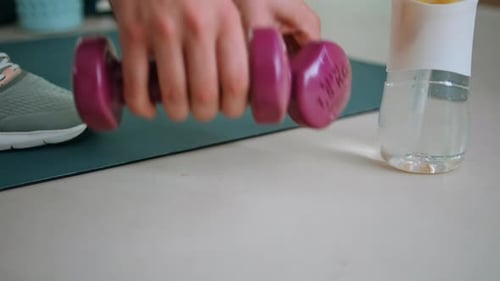 Dumbbells Placed on Floor Next to Fitness Mat