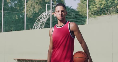 Confident Young Man Holding Basketball on Outdoor Court
