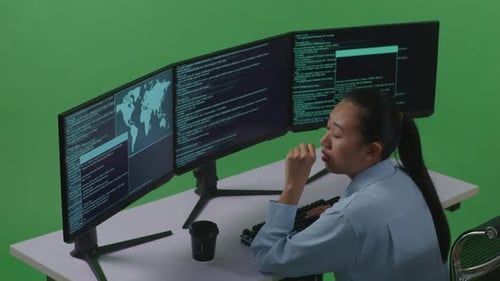 Tired Asian Woman Yawning While Write Code With Multiple Computer Screens In Green Screen