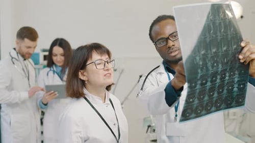 Medical Team Analyzing X-Ray in Bright Clinic