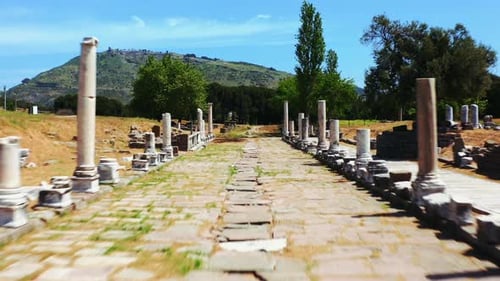 Zumbido FPV que vuela en el camino sagrado con columnas del Santuario de Asclepio. Centro Médico Asclepion
de An