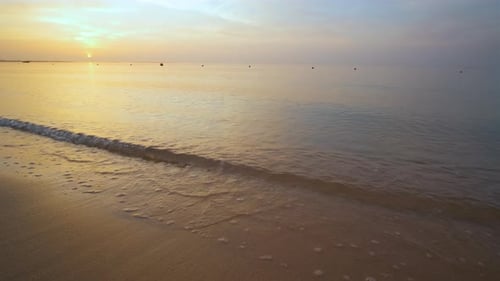 Calm Sea Shore with Crushing Waves on Sandy Beach at Sunrise