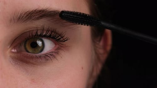 Girl Making Makeup Using Black Mascara On Her Long Eyelashes Close Up View