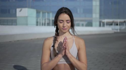 Lächelnde Yogafrau meditiert in Lotus-Pose auf der urbanen Stadtstraße im Freien