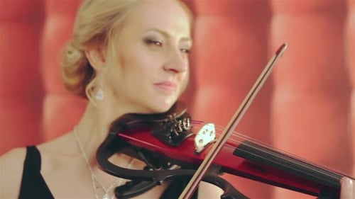 Woman Plays Red Electric Violin in Concert