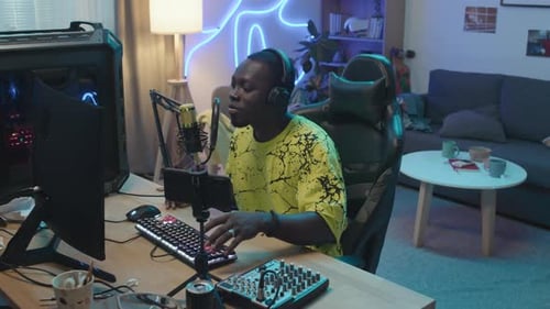 Young Black Streamer Chatting with Subscribers in his Home Studio