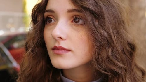 Attractive Young Woman with Wavy Hair Looking Up