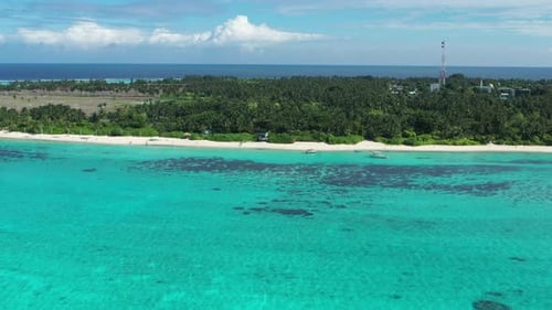 Aerial view of tropical island with turquoise water and lush greenery, Maldives.