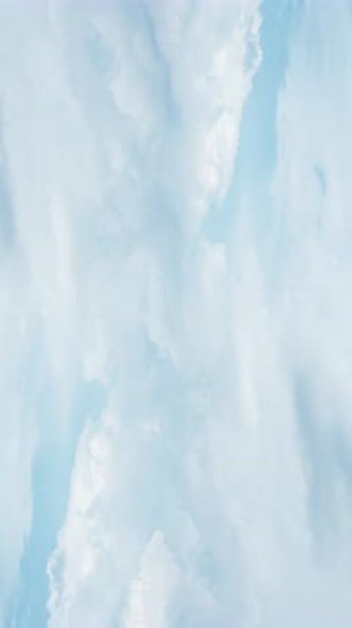Clouds Drifting Gently in Pale Blue Sky