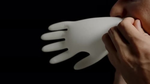 Man Puts on White Latex Glove
