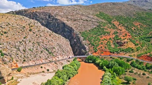 Brown River Flowing Through a Vast Canyon - Aerial View