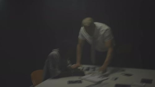 Tense Interrogation Scene Between Two Men in Dark Room