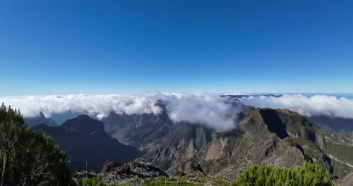 Time lapse of clouds flowing over the mountain range on a sunny day on an island.