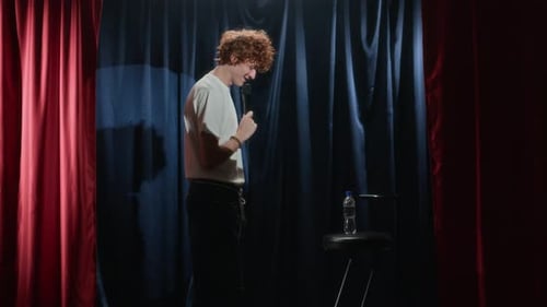 Male Comedian Casually Walking on Stage with Microphone and Telling Jokes