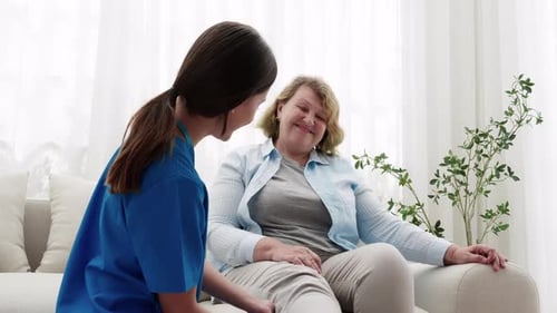 Caring Healthcare Worker Helping Smiling Senior Woman At Home