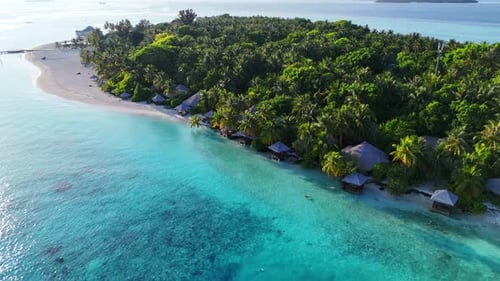 Aerial View Zoom Out of Tropical Maldives Island with Wooden Pier Surrounded By Turquoise Sea Bright