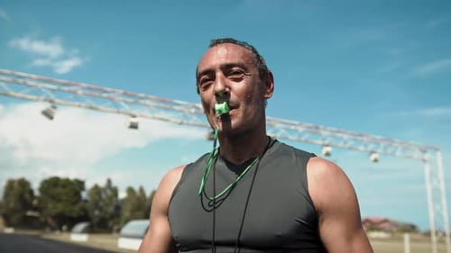 Coach Blowing Whistle at Outdoor Sports Field