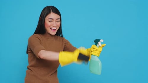 Woman Simulates Cleaning with Spray Bottle and Sponge