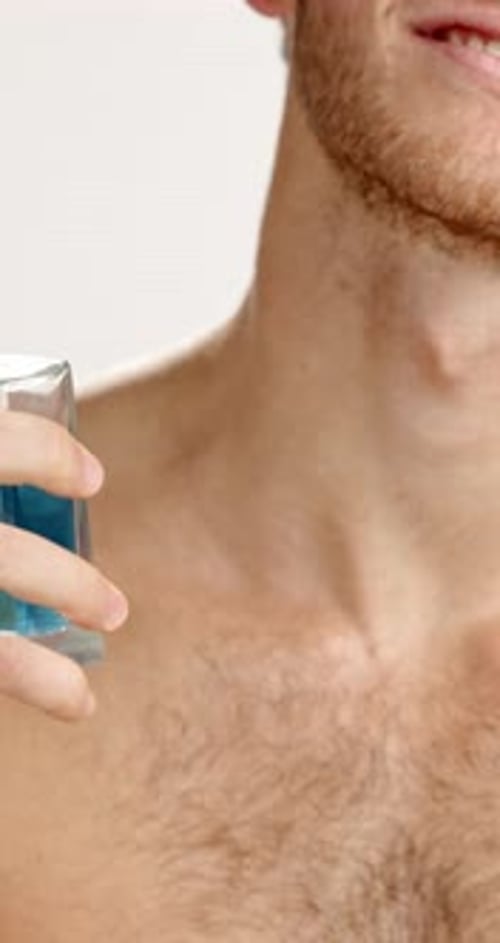 Shirtless Man Sprays Cologne on Hairy Chest
