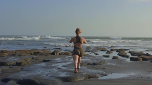 Back View of the Young Sporty Caucasian Blonde Girl Practicing Yoga Exercises Outside