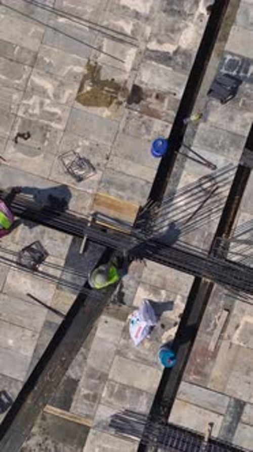 Vídeo vertical: los trabajadores construyen paredes en una obra de construcción activa para destacar el arduo trabajo de conducir