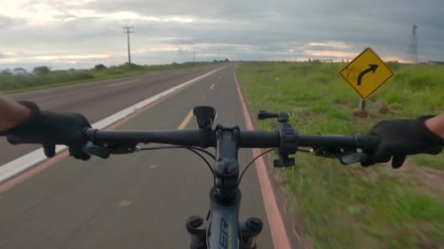 Cyclist riding on the bike path beside the highway, first person video